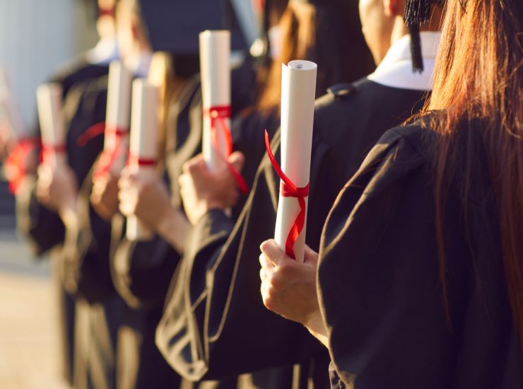 Laureati in fila mostrano la loro laurea