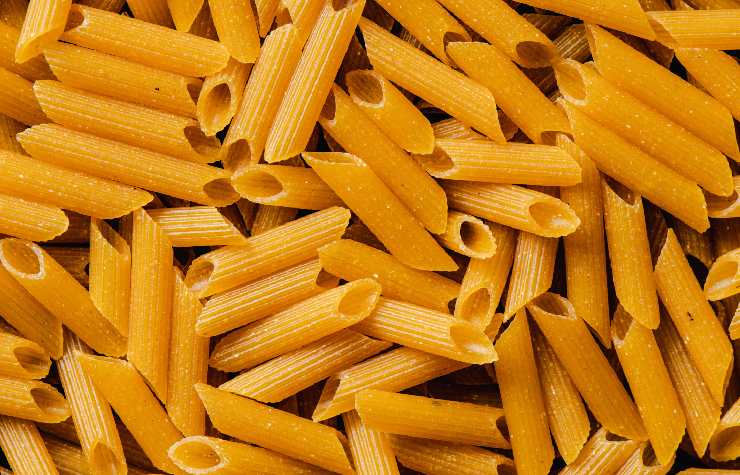 Tanta pasta cruda che forma una texture di penne rigate