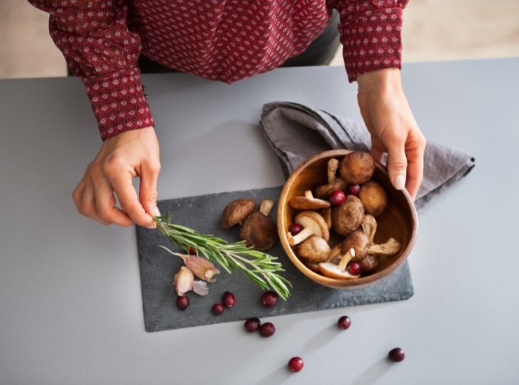 Un uomo prepara una pentola con i funghi